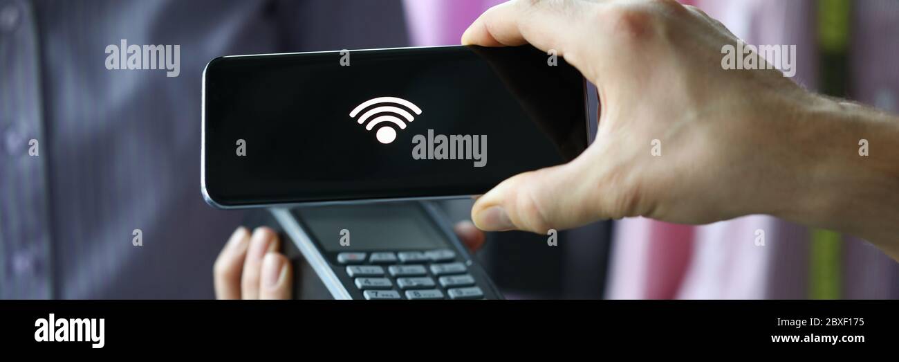 Uomo attraverso il terminale utilizzando la tecnologia Pay Pass Foto Stock