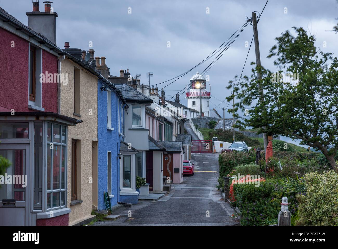 Roches Point, Cork, Irlanda. 07 giugno 2020. Strada che passa la casa fino al faro di Roches Point, Cork, Irlanda. Situato all'ingresso del porto di Cork, il faro di Roches Point fu fondato nel 1817. La torre originale era considerata troppo piccola e nel 1835 fu sostituita dalla torre più grande presente. Il tempo è fresco, piuttosto nuvoloso e soprattutto secco oggi. Questo pomeriggio, con gli incantesimi soleggiati in via di sviluppo, si illuminano di più. Moderate brezze da nord a nord-ovest, fresche nelle aree costiere di questa mattina e pomeriggio alti da 16 a 18 gradi Celsius. - credito; David Creedon / Alamy Live NE Foto Stock