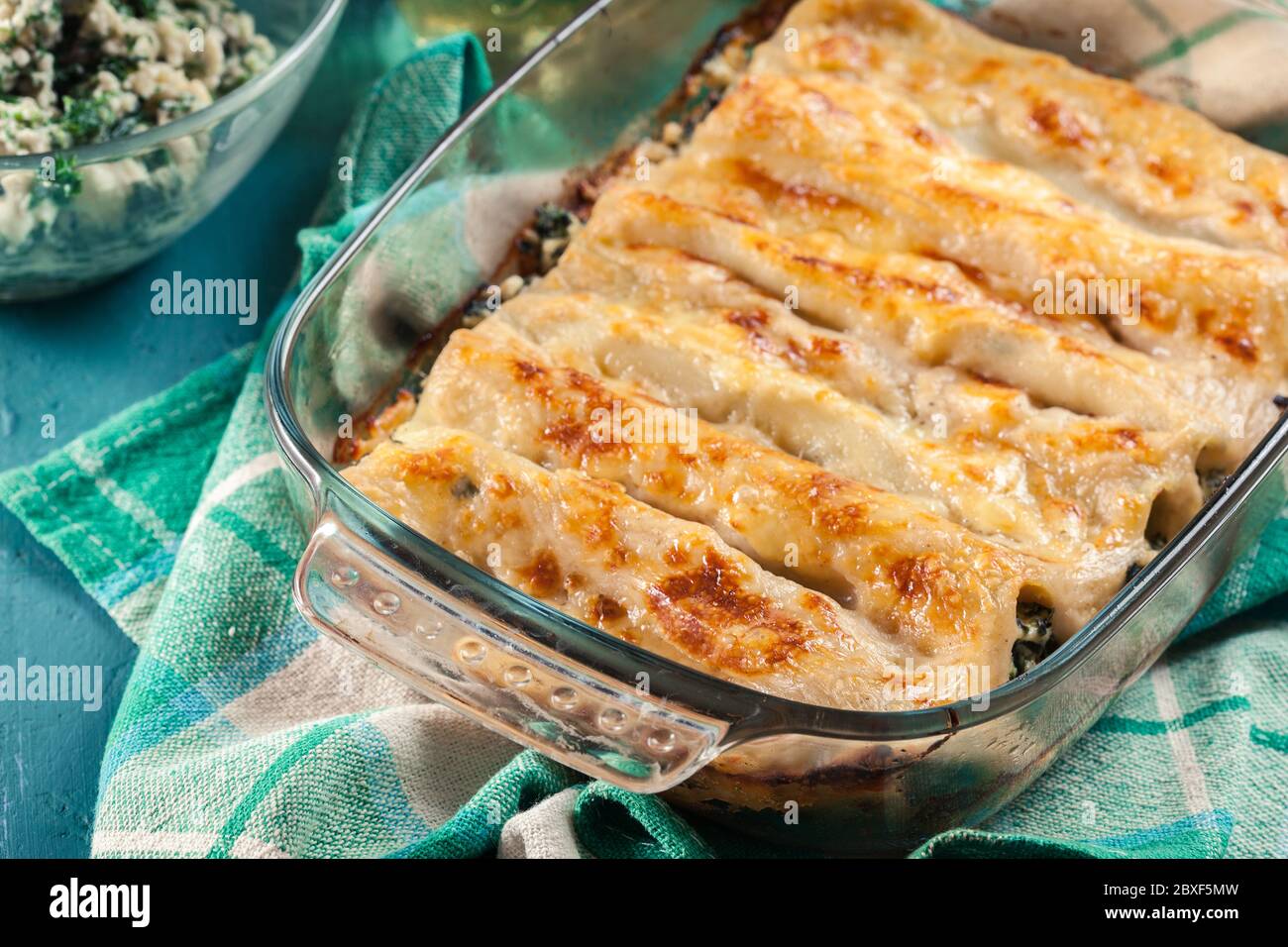 Cannelloni farciti con spinaci in casseruola. Cucina italiana Foto Stock