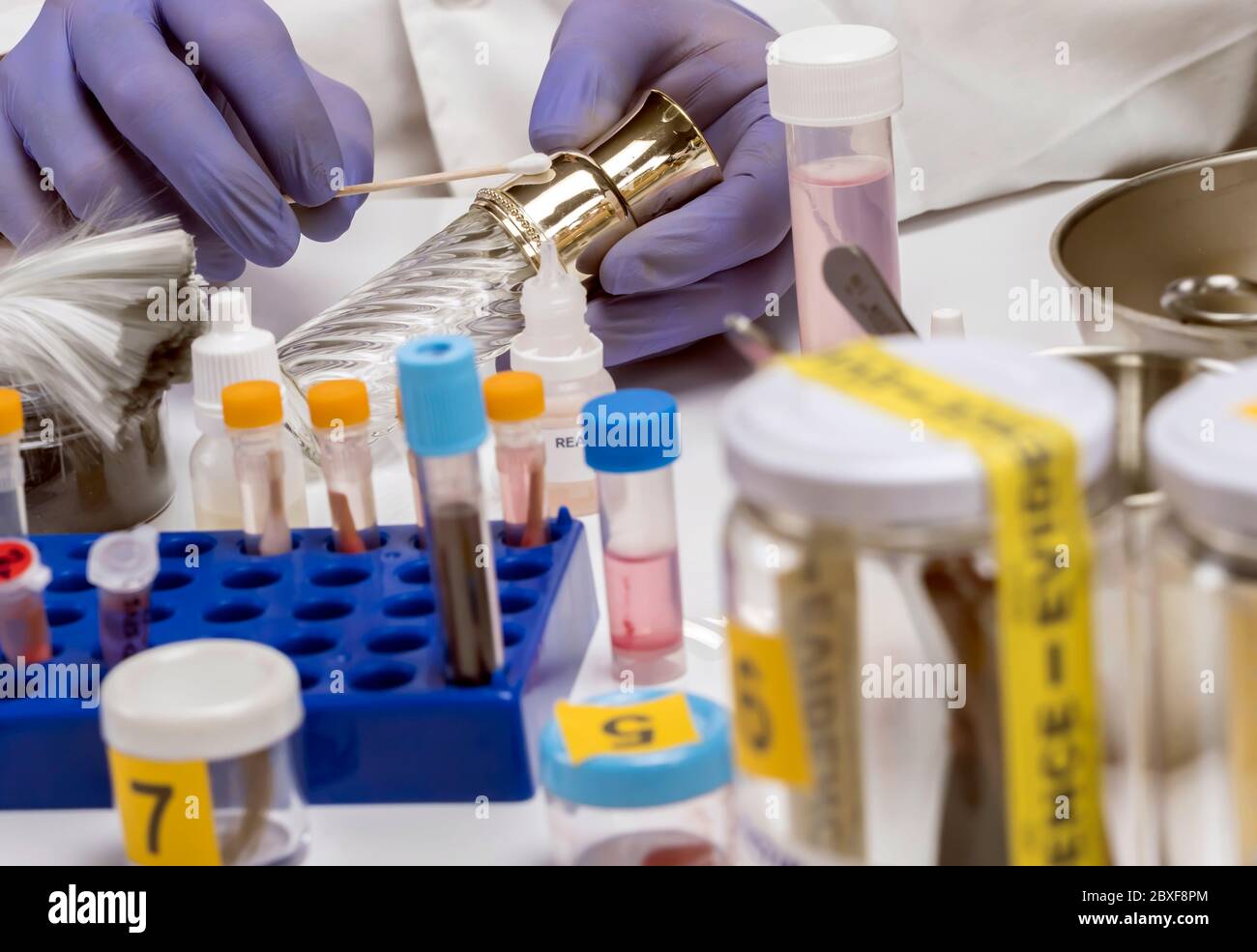 Polizia specializzata prendere campione di DNA da bottiglia di profumo della vittima di omicidio Foto Stock