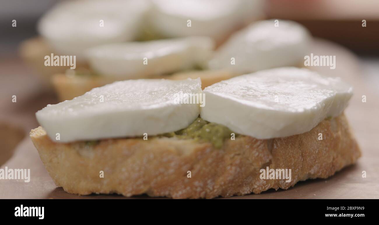 fette di mozzarella sulla ciabatta con pesto su tavola di olive Foto Stock