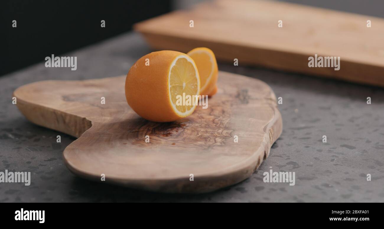 tagliare il limone d'arancia fresco sul bordo dell'olivo Foto Stock