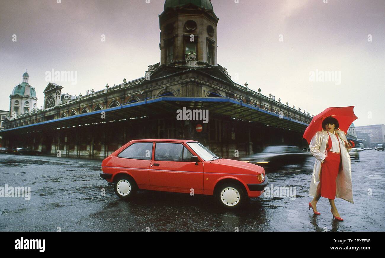 Giovane donna con la sua Ford Fiesta Finesse 1986 a Londra UK Foto Stock