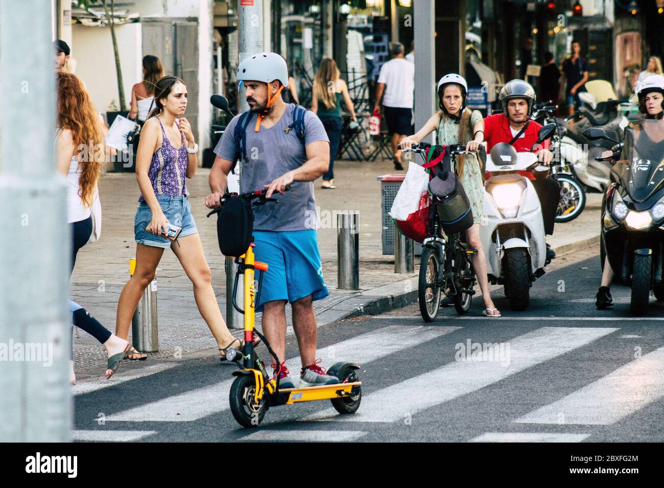 Tel Aviv Israele 9 agosto 2019 Vista di persone israeliane sconosciute che rotolano con uno scooter elettrico nelle strade di Tel Aviv nel pomeriggio Foto Stock