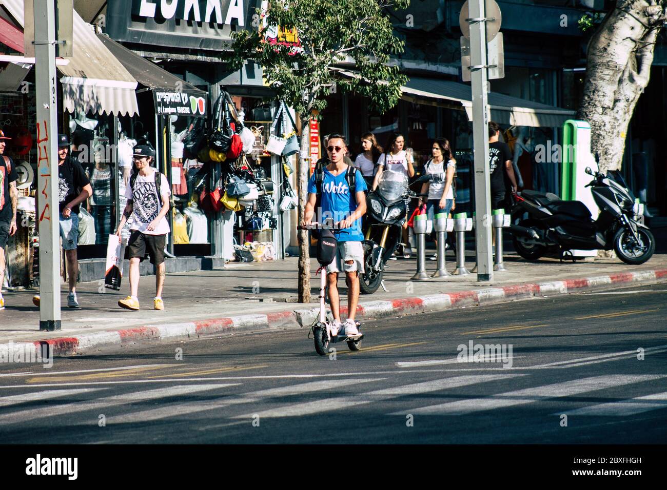 Tel Aviv Israele 9 agosto 2019 Vista di persone israeliane sconosciute che rotolano con uno scooter elettrico nelle strade di Tel Aviv nel pomeriggio Foto Stock