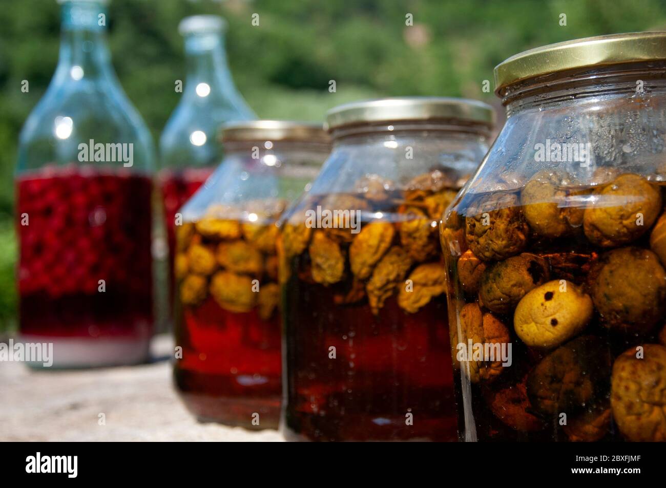Vasetti di vetro con mele fermentanti e zucchero come tecnica artigianale di produzione di liquori a basso contenuto alcolico nella regione dei Balcani. Foto Stock