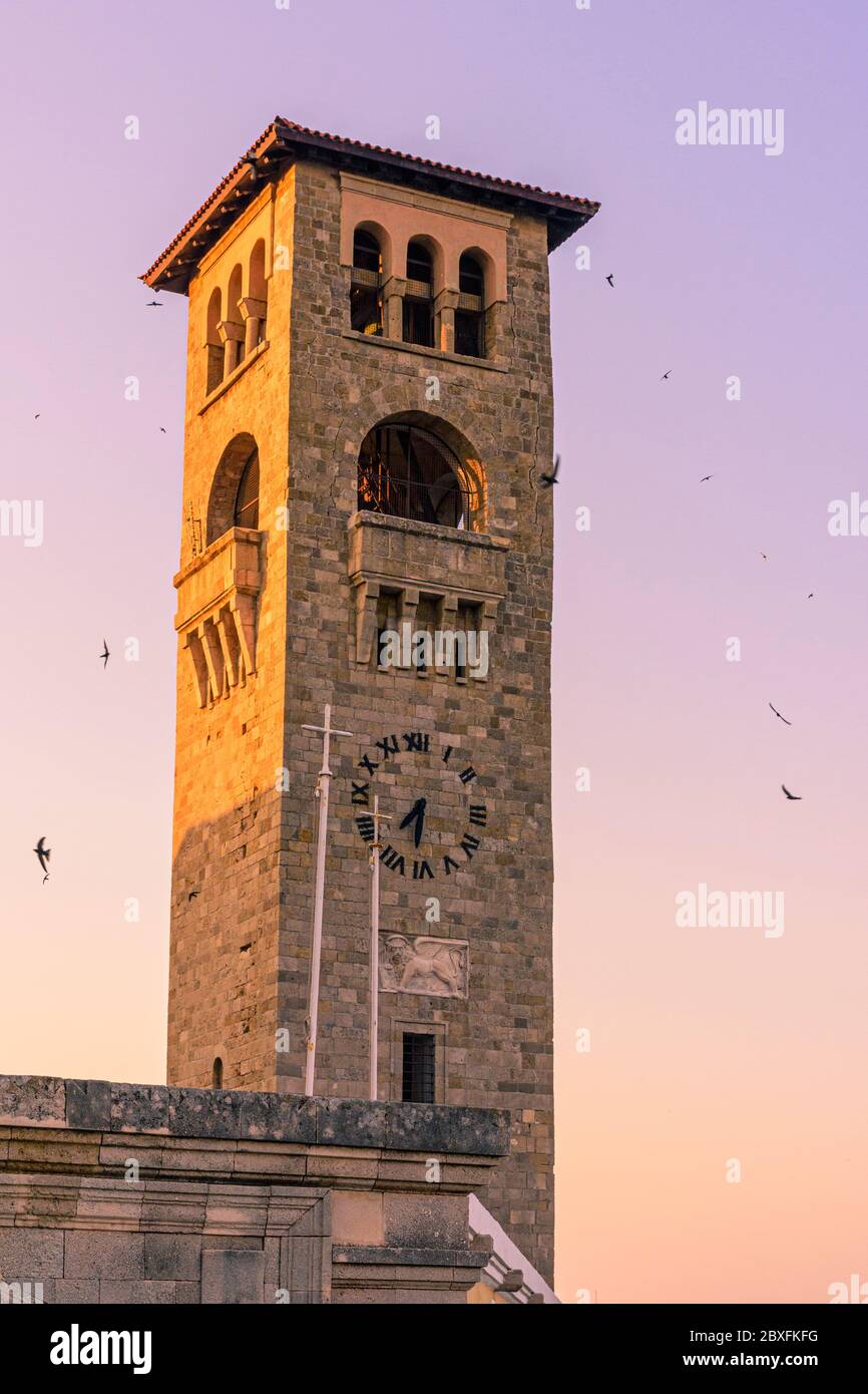 Lungomare al tramonto intorno al campanile della Chiesa dell'Annunciazione della Vergine, Rodi città, Dodecanese, Grecia Foto Stock