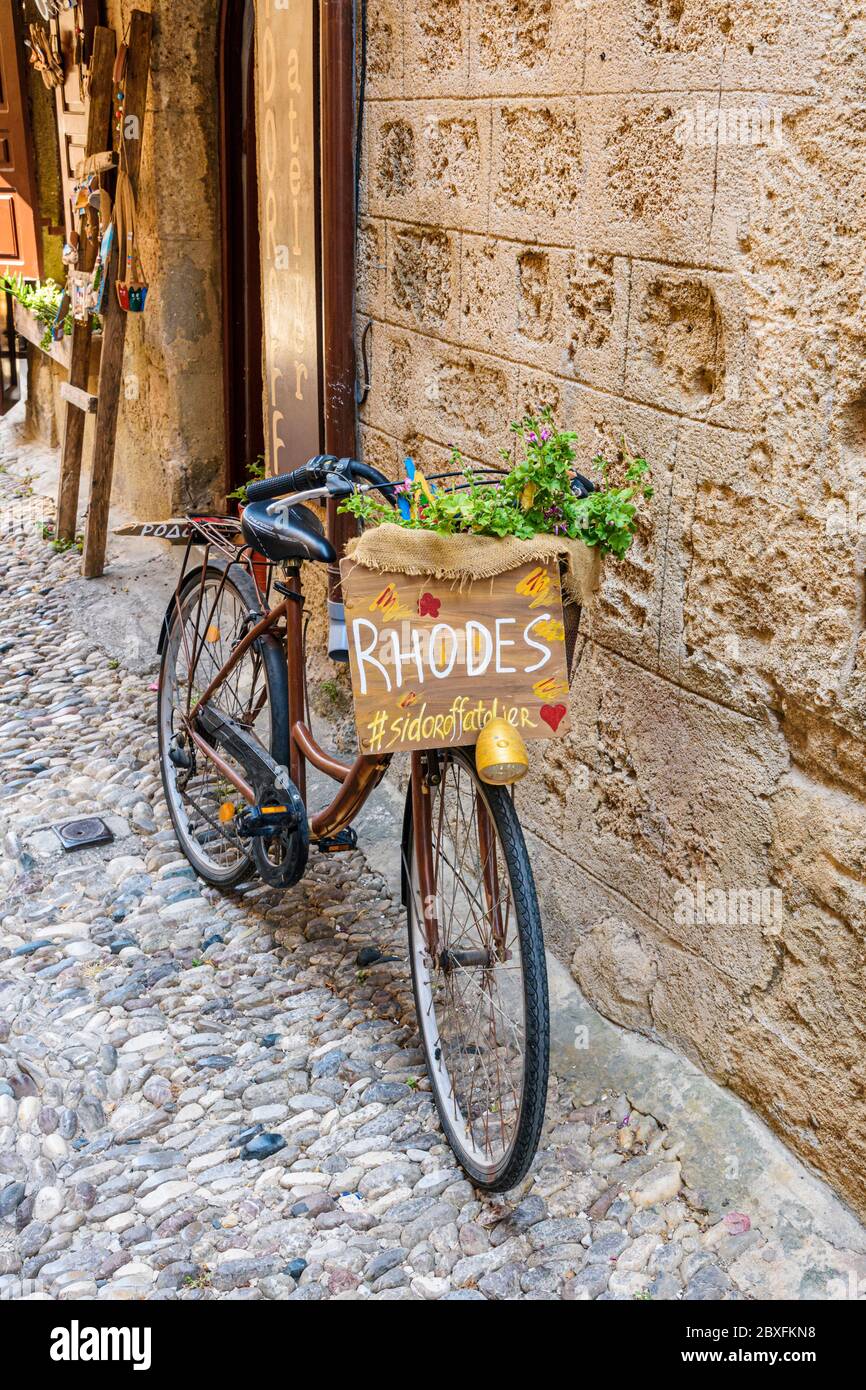 Bicicletta appoggiata a un muro di pietra nella vecchia città medievale di Rodi, Isola di Rodi, Grecia Foto Stock
