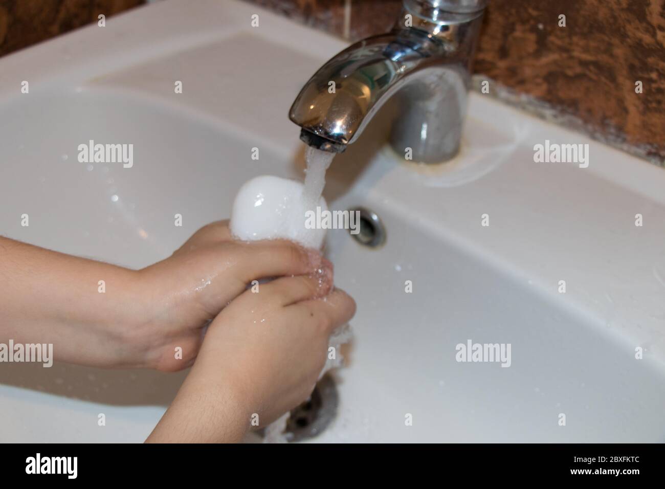 Il bambino si è lavato la mano con sapone. Modi per proteggere contro i germi Foto Stock