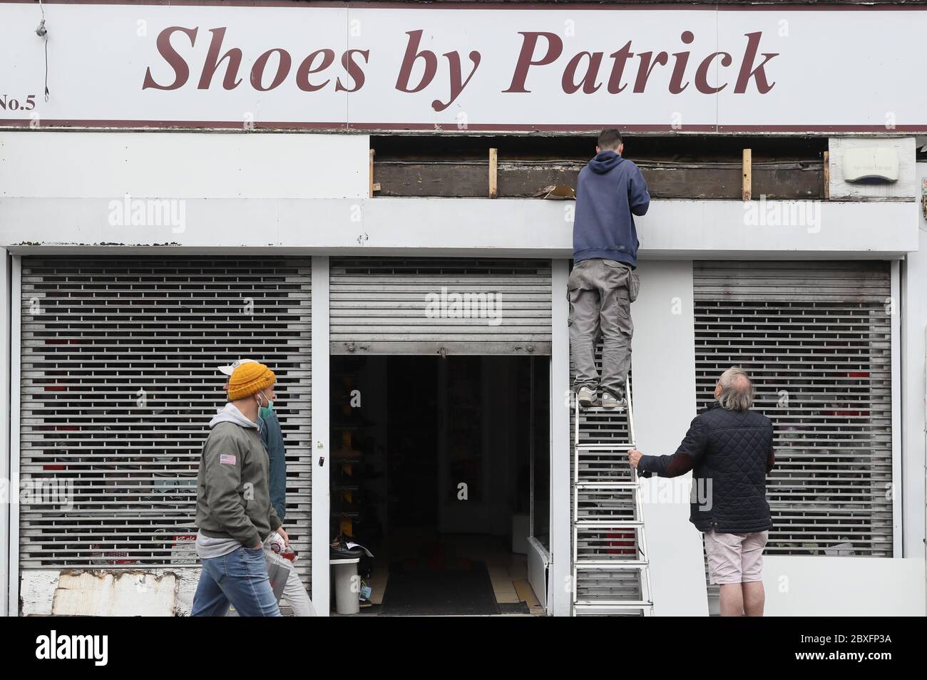 La gente passa davanti al negozio The Shoes by Patrick di Dublino in vista della sua riapertura, mentre la seconda fase della mappa stradale irlandese per il recupero del coronavirus inizierà lunedì come previsto, insieme ad altre misure originariamente previste per le fasi successive. Foto Stock