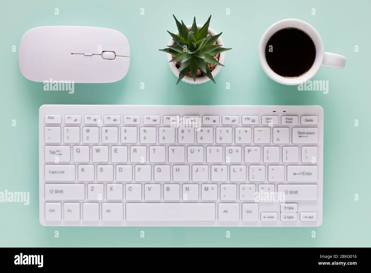 ufficio, tastiera per computer con tazza da caffè, oggetti disposti in modo uniforme, colori brillanti, vista dall'alto Foto Stock