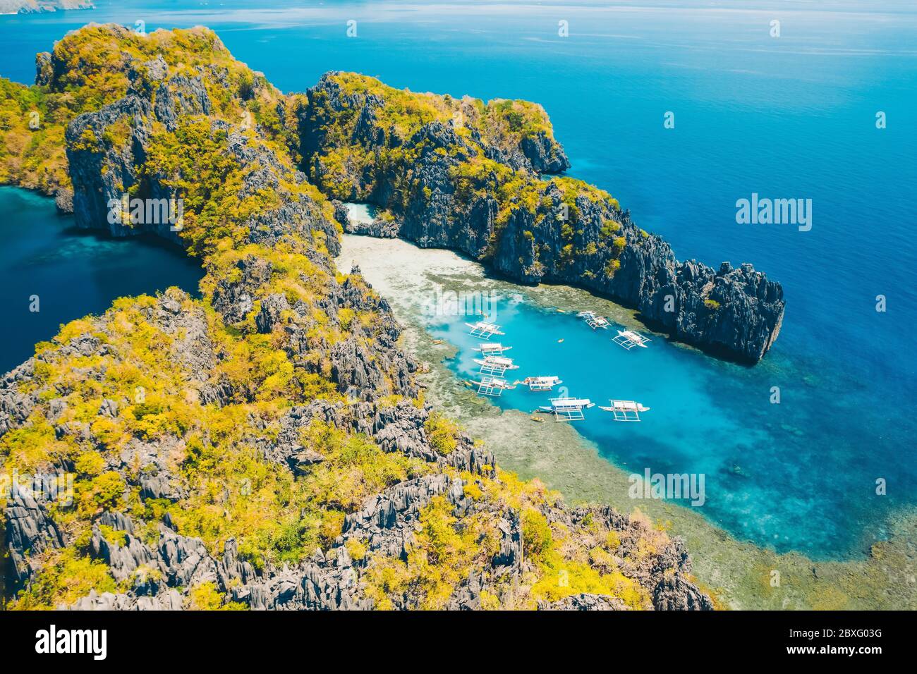 Barche turistiche in tour in grande e laguna, vista aerea. Paesaggio tropicale. El Nido, isola di Palawan, Filippine Foto Stock