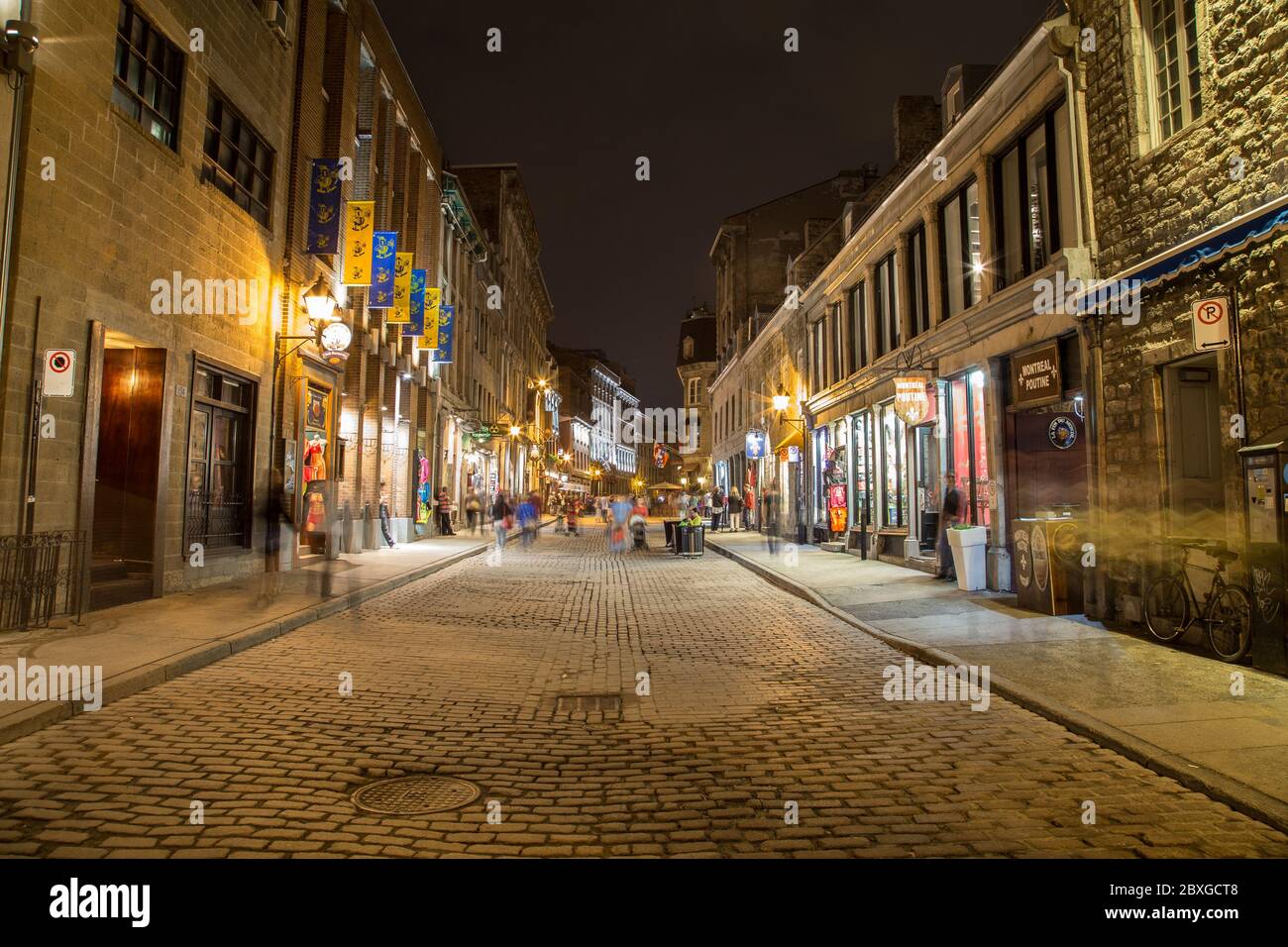 MONTREAL, CANADA - 17 MAGGIO 2015: Edifici e aziende lungo Rue Saint Paul nella città vecchia di Montreal di notte. La sfocatura delle persone può essere vista. Foto Stock
