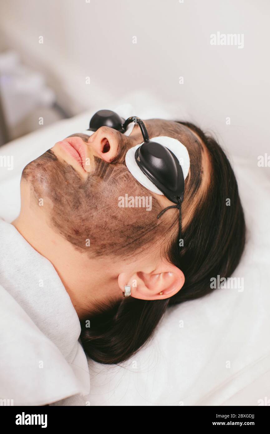 Donna che ha un trattamento di bellezza di buccia di carbonio Foto Stock