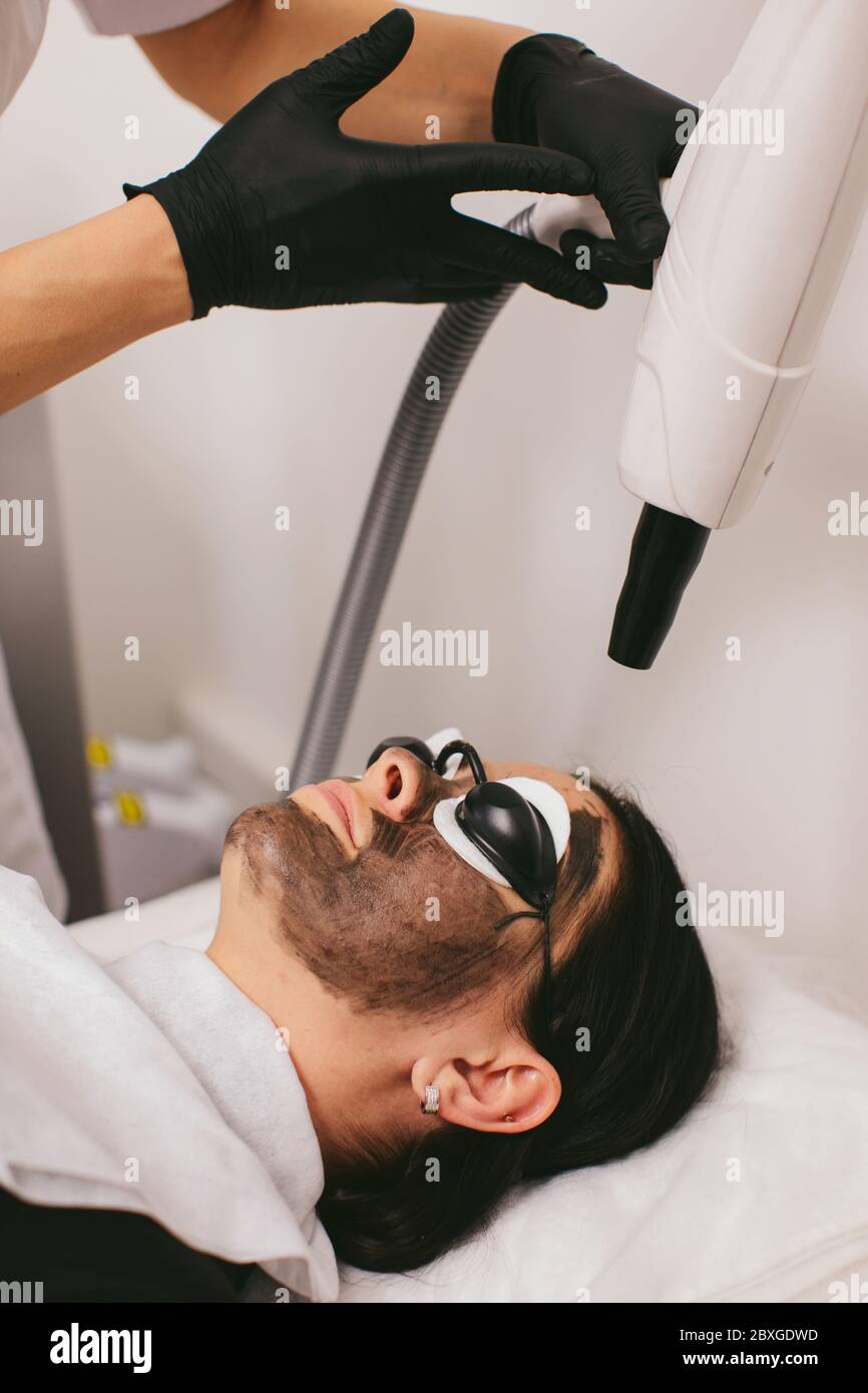 Donna che ha un trattamento di bellezza di buccia di carbonio Foto Stock