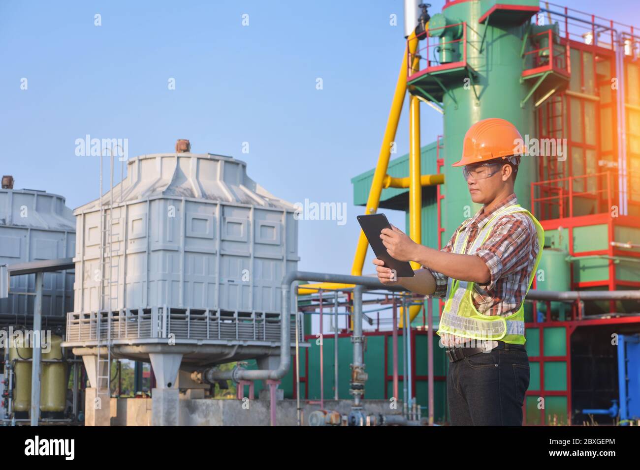 Ingegnere in una centrale elettrica utilizzando un tablet digitale, Thailandia Foto Stock