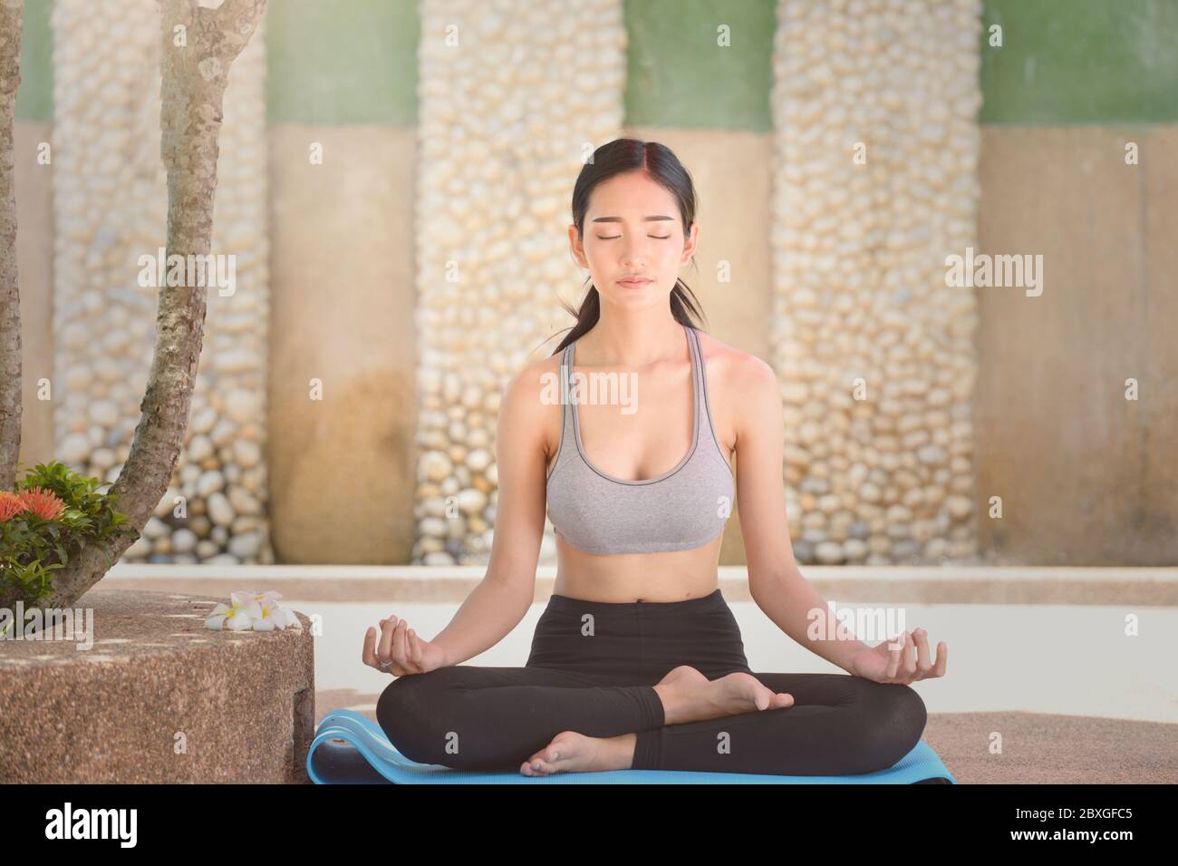 Bella donna seduta in loto posa meditating, Thailandia Foto Stock