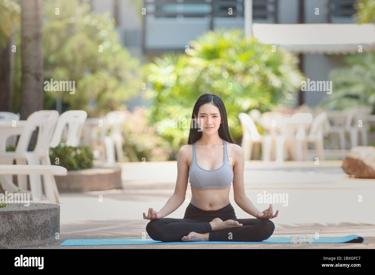 Bella donna seduta in loto posa meditating, Thailandia Foto Stock