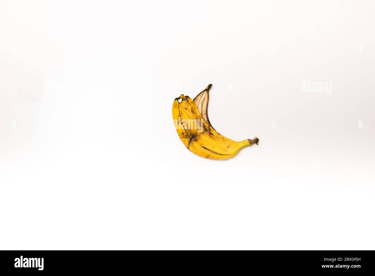 buccia di banana rovinata su uno sfondo bianco isolato Foto Stock