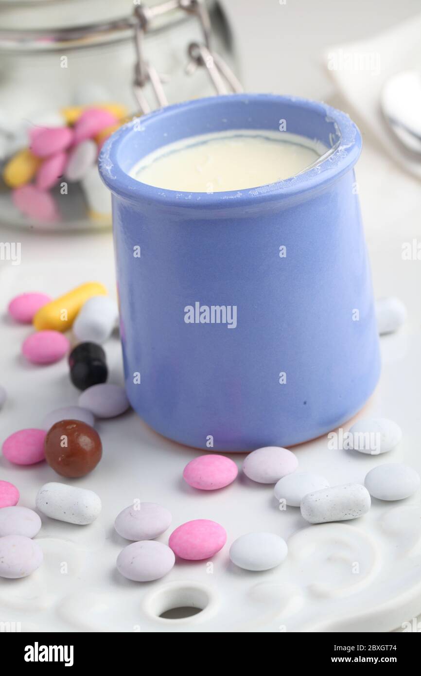 Un vasetto di yogurt alla vaniglia e caramelle Foto Stock