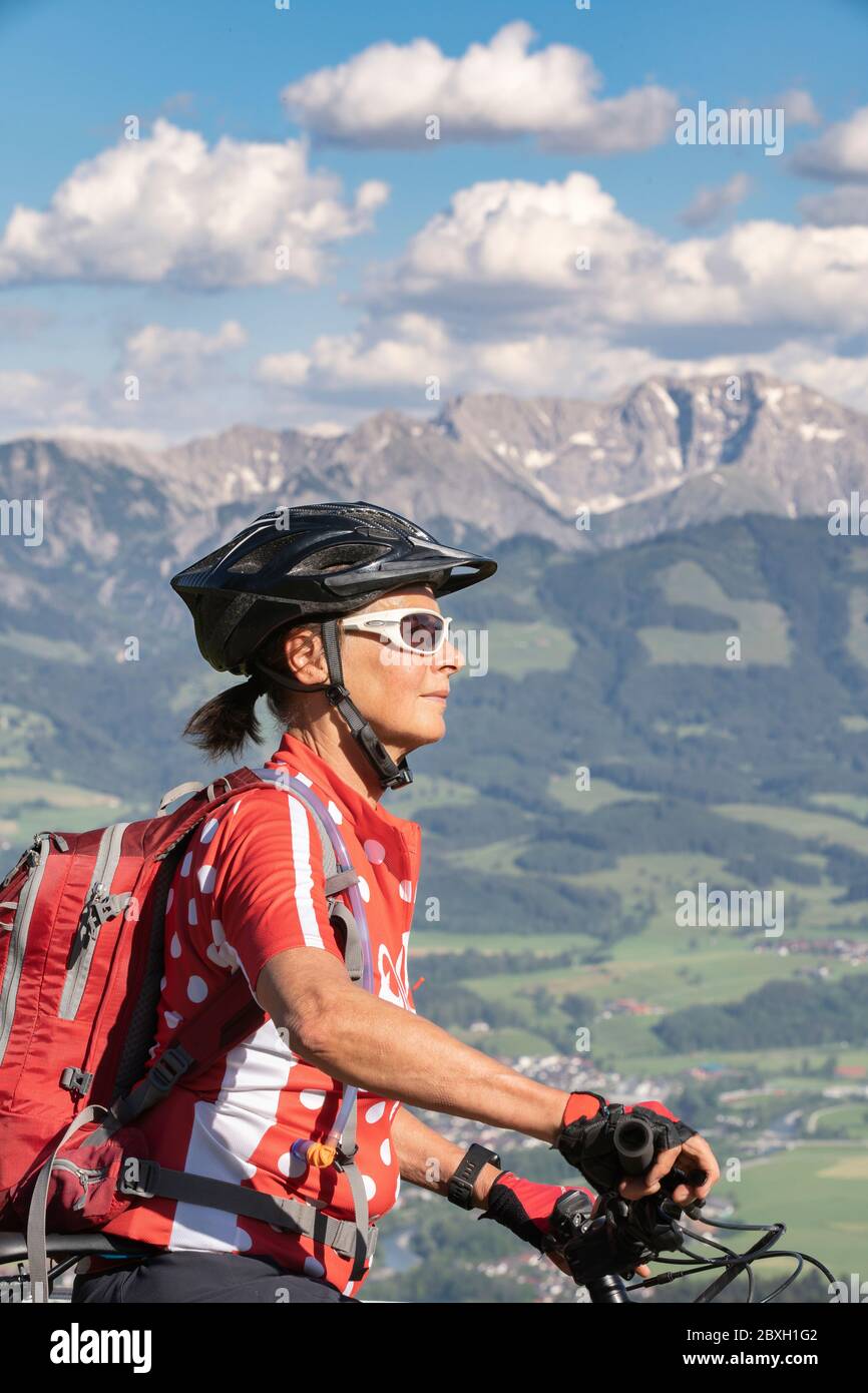 Donna anziana che cavalca la sua mountain bike elettrica sulle montagne sopra la valle dell'Iller tra Sonthofen e Oberstdorf, Alpi Allgau, Baviera G. Foto Stock