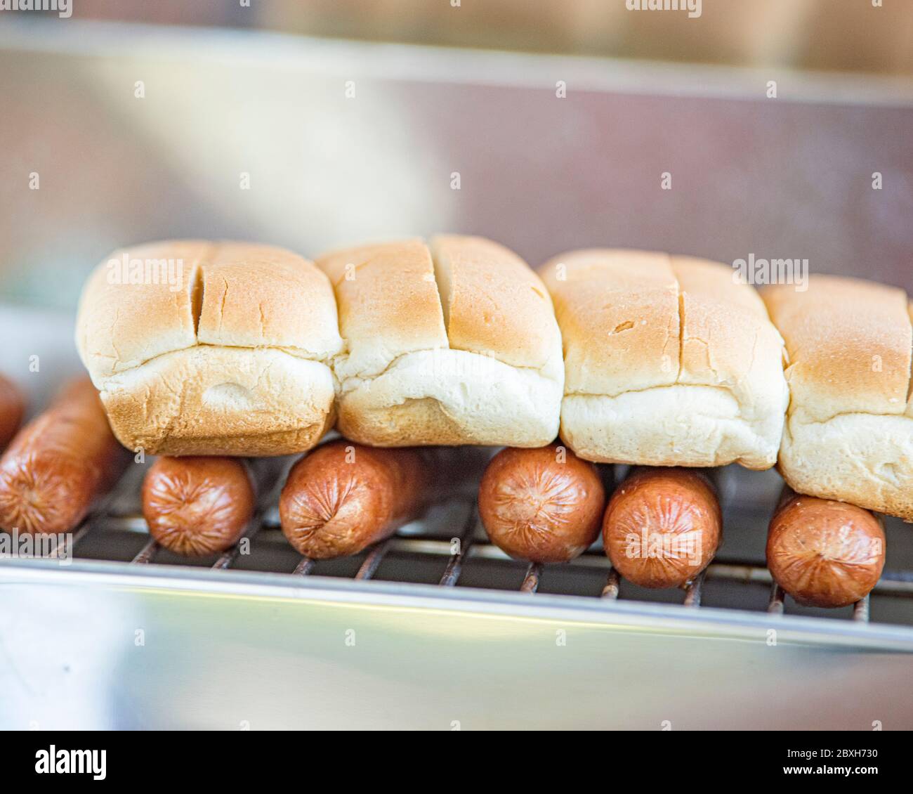 molti hot dog su una griglia con panini in cima. Primo piano Foto Stock