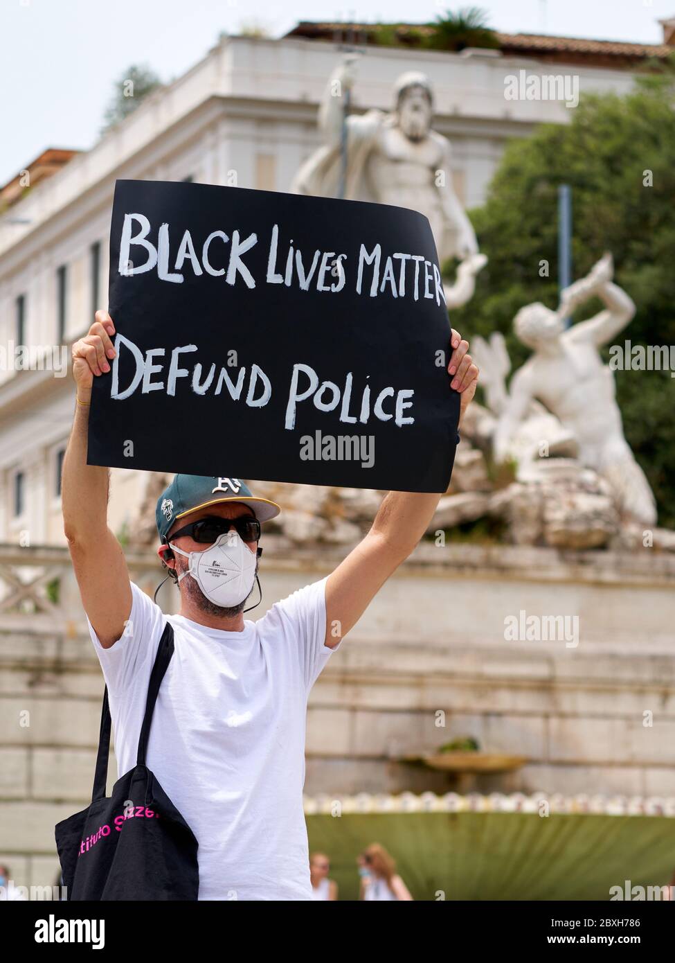 Black Lives Matter, dimostrazione in memoria di George Floyd contro il razzismo. Young Man Holding segno lettura: 'Black Lives materia. Defund Police' Foto Stock