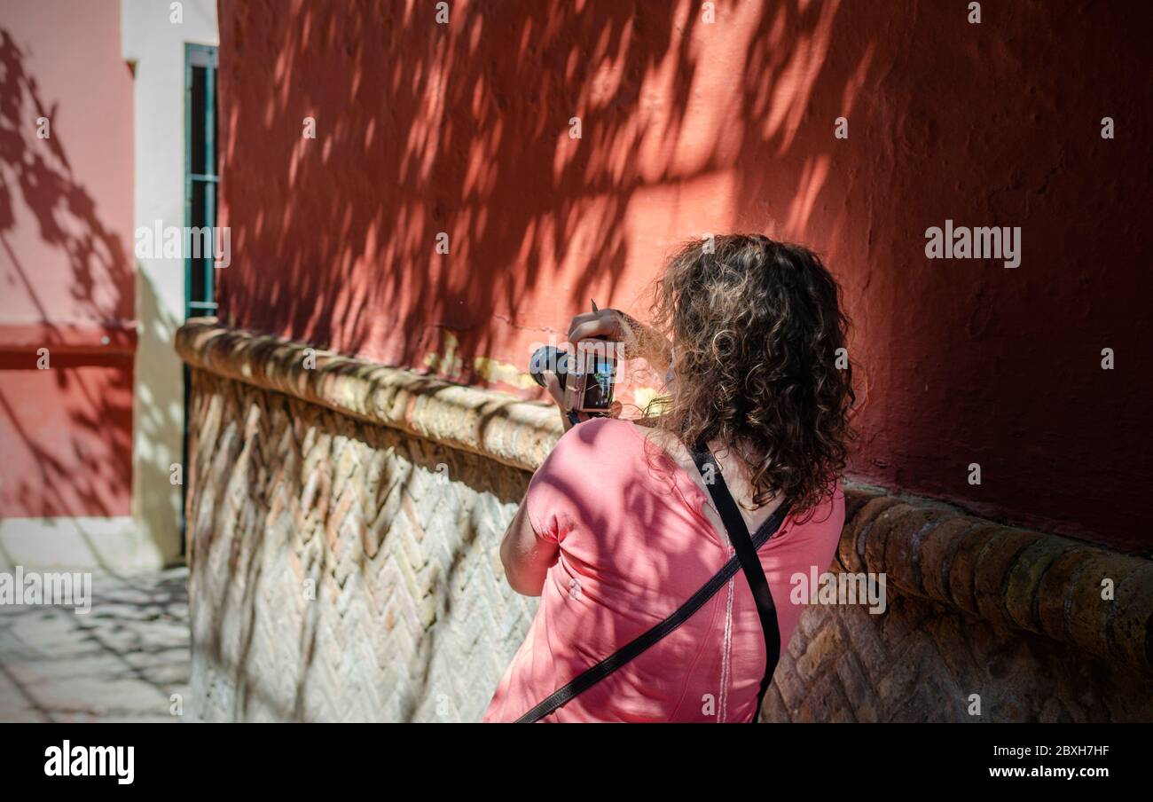 Donna caucasica scattando foto su una strada turistica di Siviglia, Spagna dopo il blocco del coronavirus Foto Stock