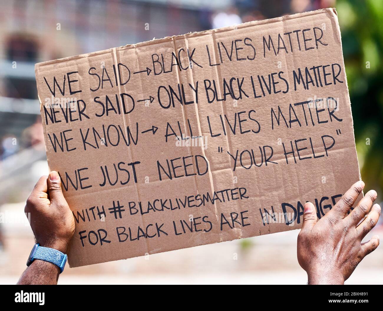 Black Lives Matter, dimostrazione in memoria di George Floyd contro il razzismo. Mani nere che alzano un segno con la scrittura circa 'le cose in tensione nere', aiuto Foto Stock