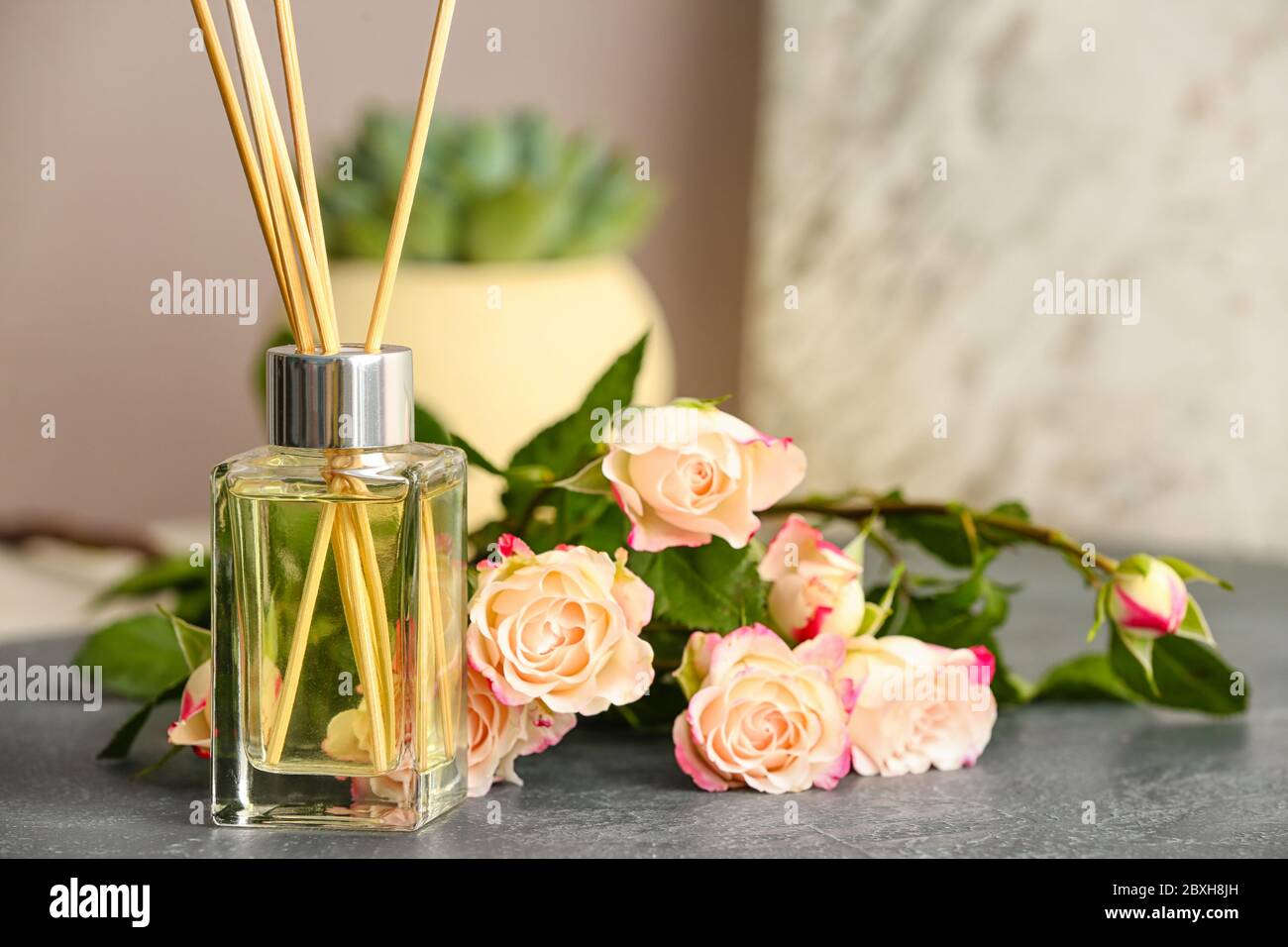 Diffusore di Reed e fiori sul tavolo Foto Stock