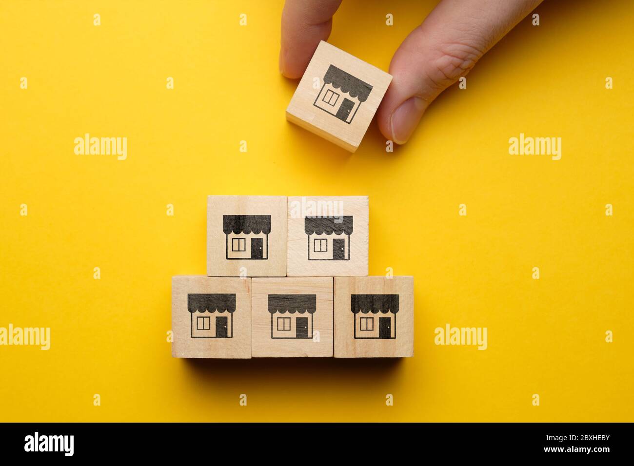 Concetto di organizzazione di una catena di negozi con icone su cubi di legno Foto Stock