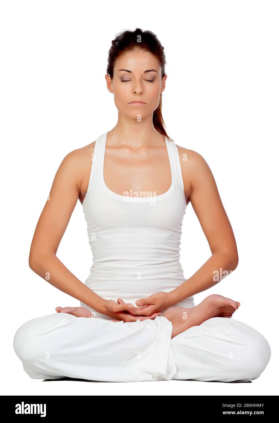 Donna bruna che fa yoga indossando abbigliamento sportivo bianco Foto Stock