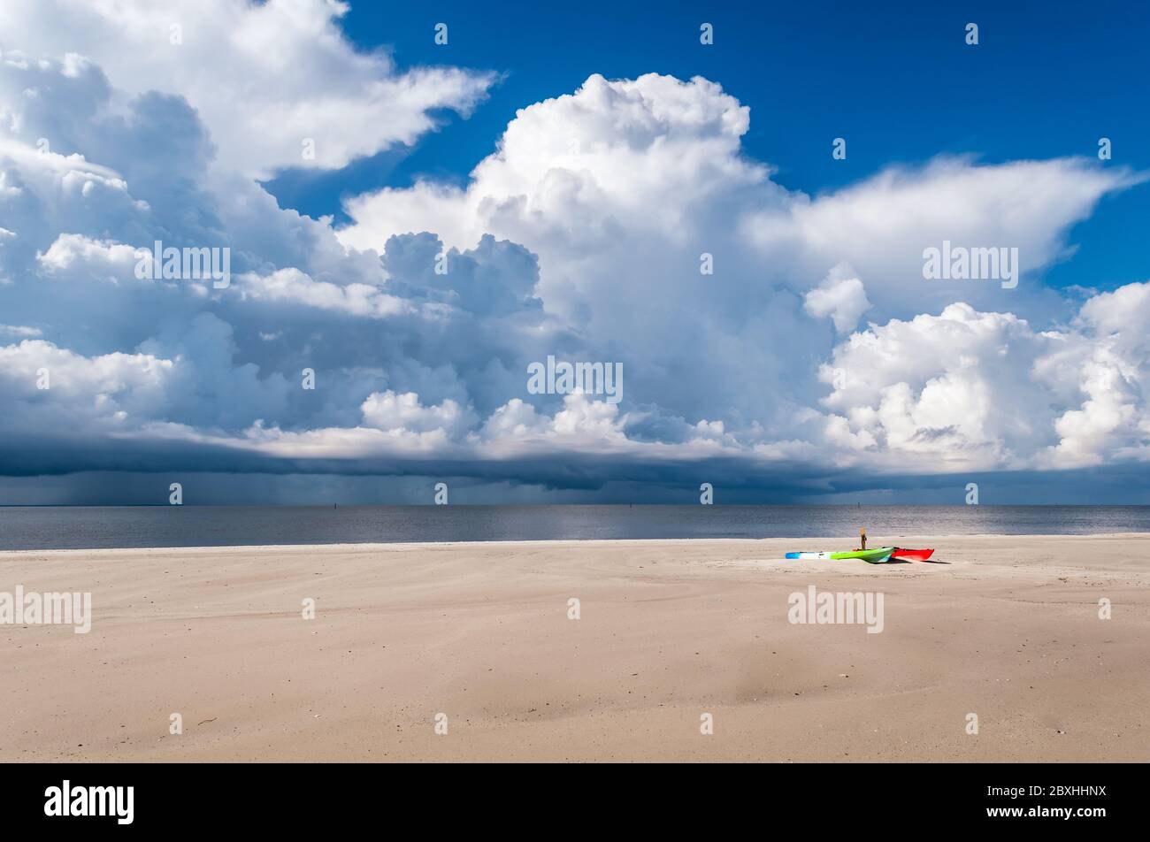 Spiaggia deserta e kayak come una tempesta sopra il Sound si avvicina alla costa del Golfo del Mississippi. Foto Stock