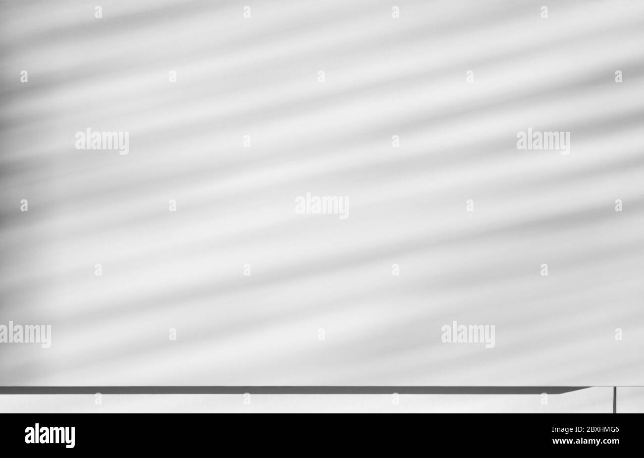 Gioco di luci e ombre, ombre a strisce diagonali su una parete bianca. Abstact sfondo con texture full frame con spazio per la copia. Foto Stock