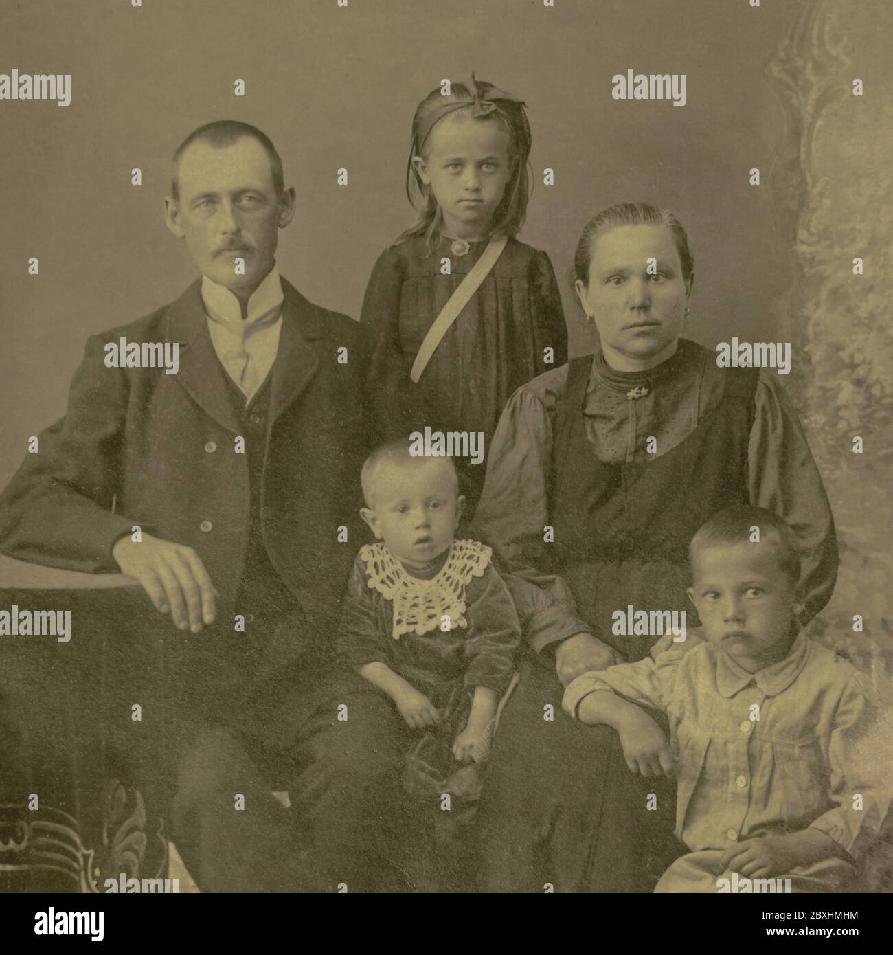 Russia - CIRCA 1910: Un studio di famiglia girato di coppia sposata con tre bambini in studio. Vintage carte de Viste foto dell'epoca edoardiana Foto Stock