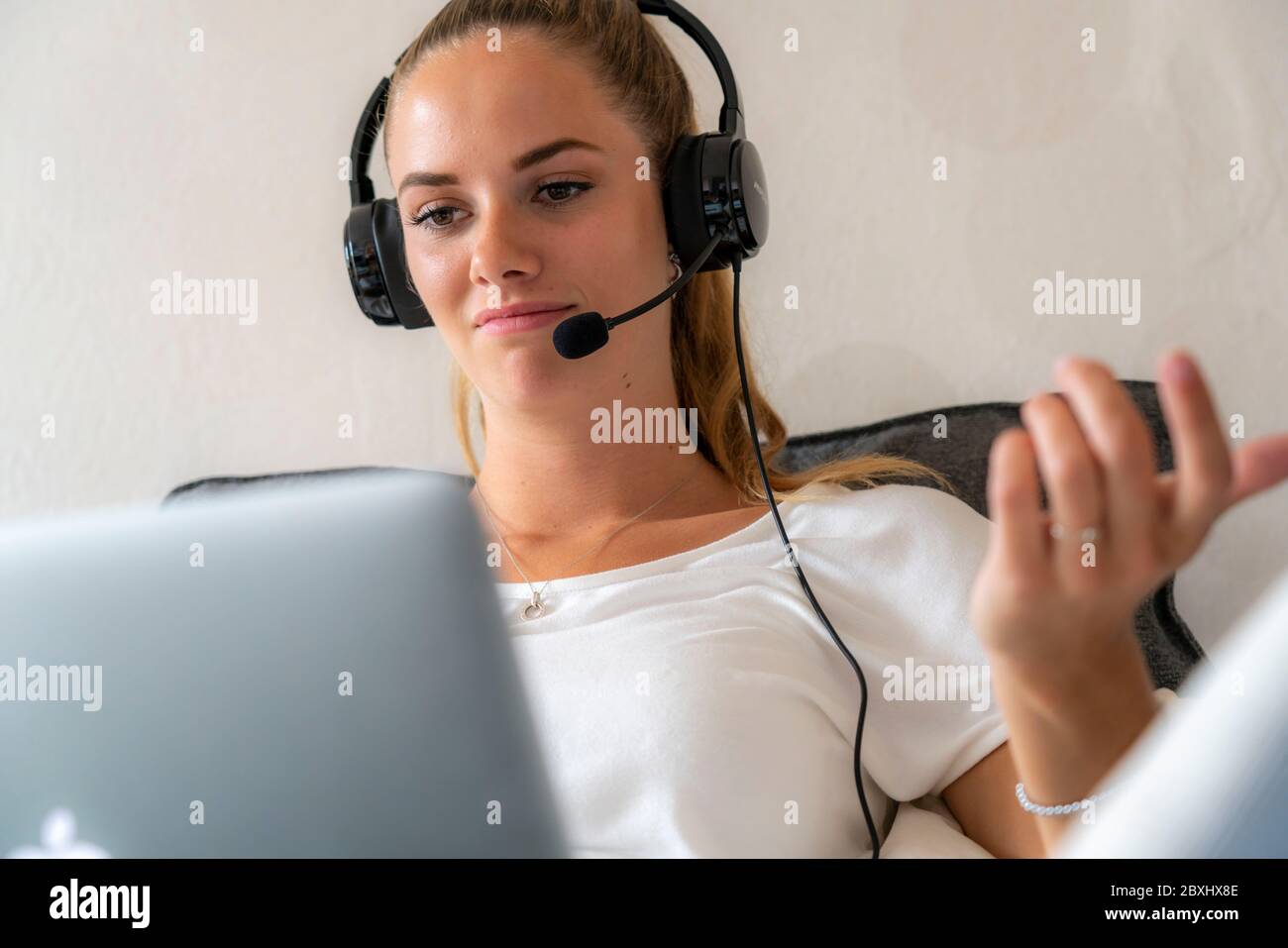 Il giovane studente impara a casa, online, in conversazione con altri studenti Foto Stock