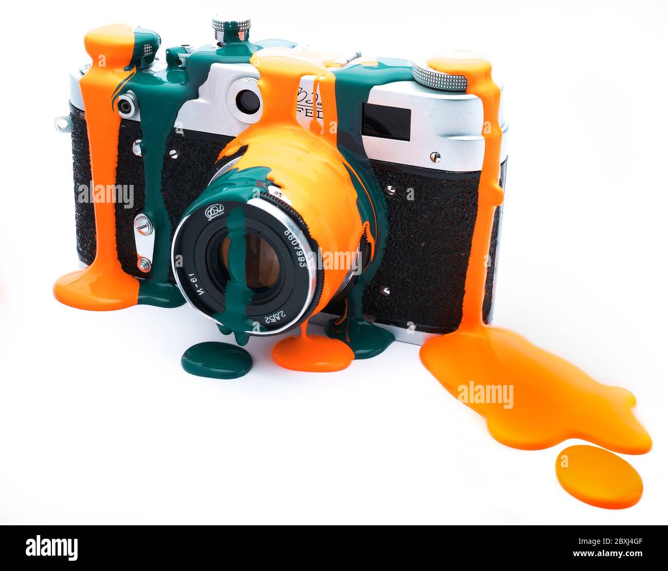 Fotocamera rangefinder russa d'epoca che gocciola a colori, arancione e teal. Foto Stock