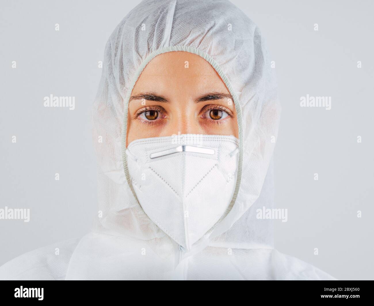 Medico caucasico. Scienziato o infermiere stanco e esausto che indossa maschera e tuta protettiva contro i rischi biologici. Mostra paura della situazione. Coro Foto Stock