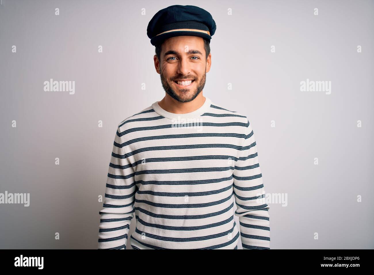 Giovane marinaio con barba che indossa divisa a righe navy e cappello da  capitano con un sorriso felice e fresco sul viso. Persona fortunata Foto  stock - Alamy