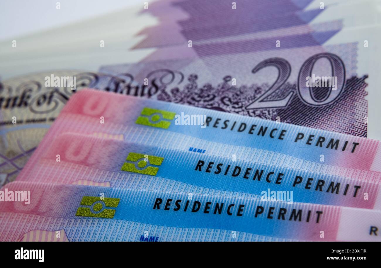 UK Biometric Residence carte di permesso e banconote da 20 libbre. Carte BRP rilasciate per gli immigrati con visto di lavoro di livello 2. Immagine concettuale del prezzo del visto. Foto Stock