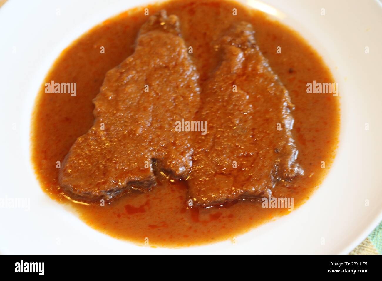 fette di carne brasate nel piatto con salsa Foto Stock