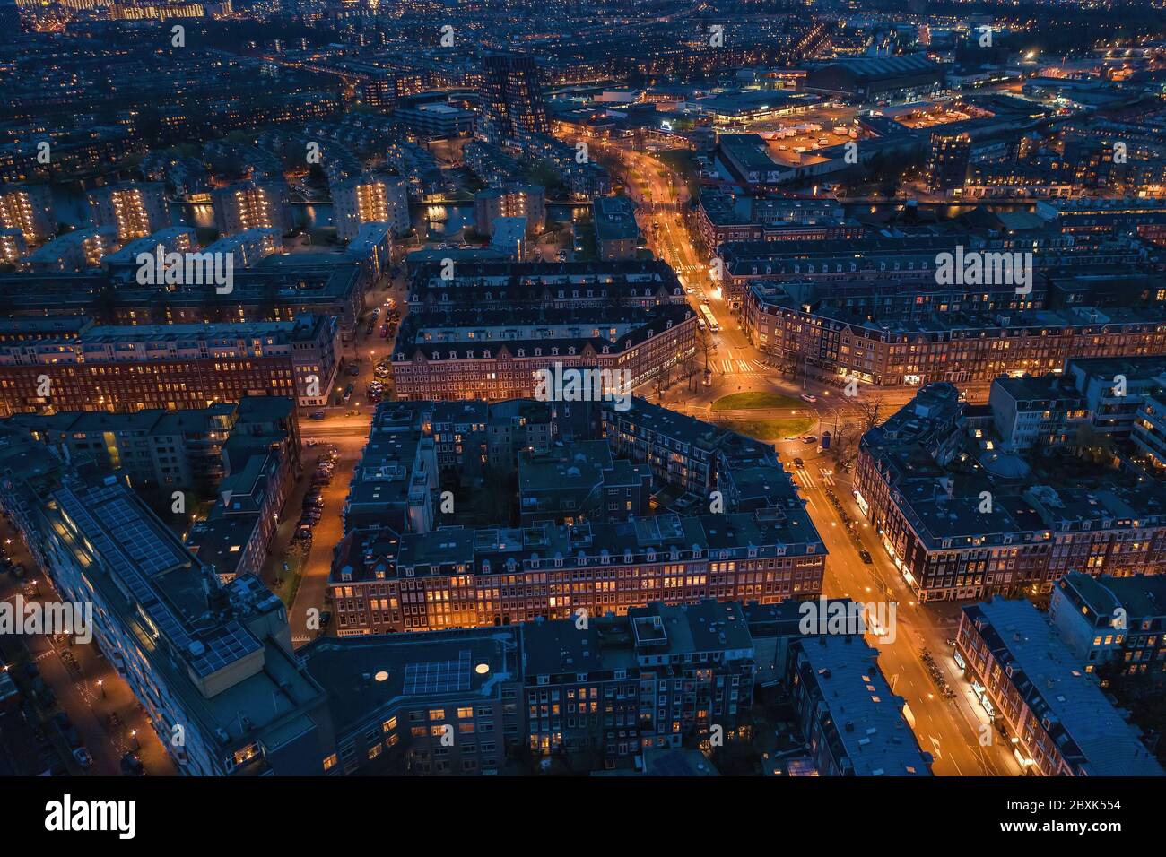 Amsterdam, Paesi Bassi. Vista aerea dal drone del centro storico con famose case da ballo e strade illuminate di notte. Foto Stock