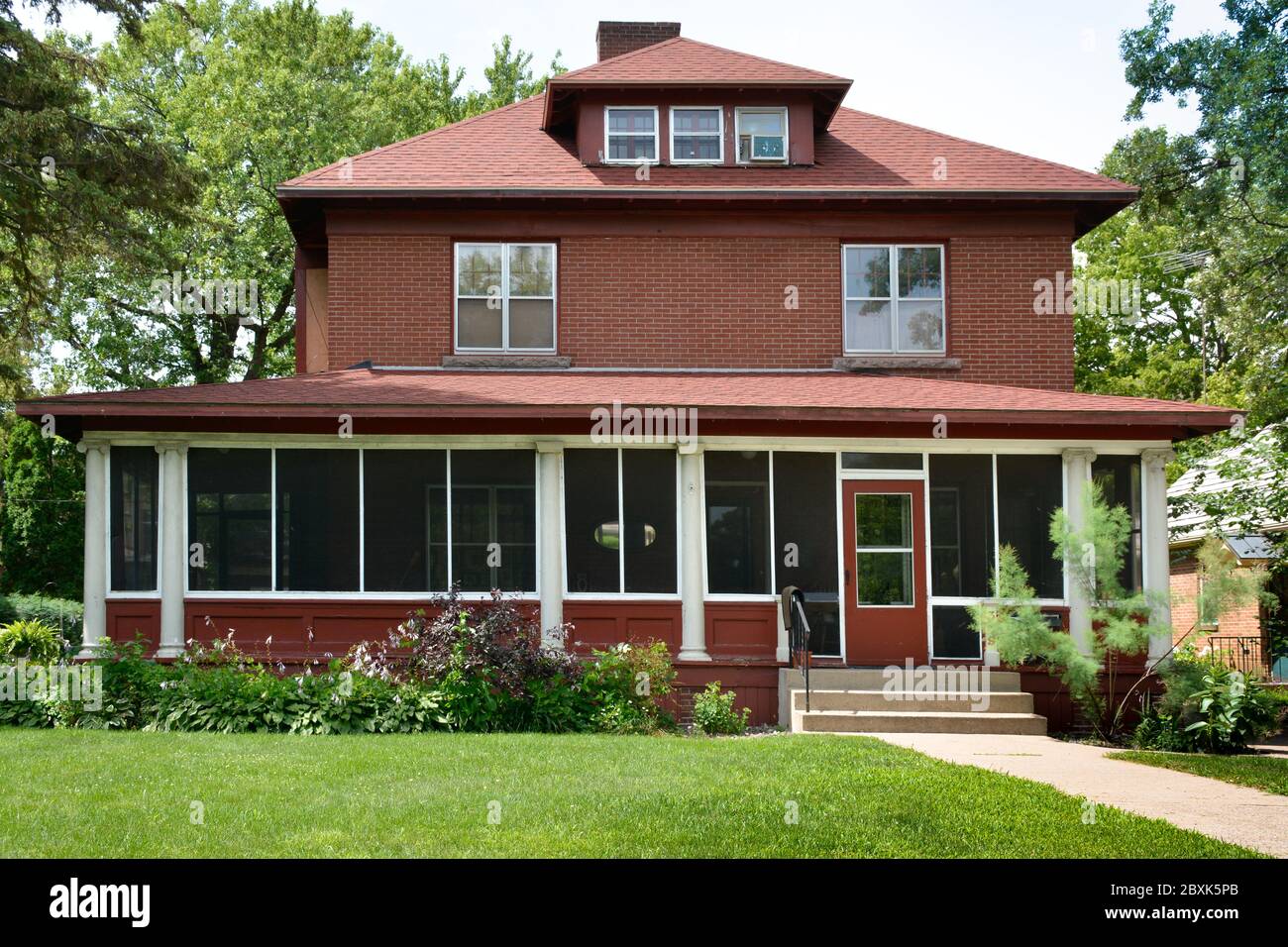 Una bella casa storica nella piccola città America, in un cortile Midwest con grande portico schermato a St. Cloud, Minnesota, USA Foto Stock