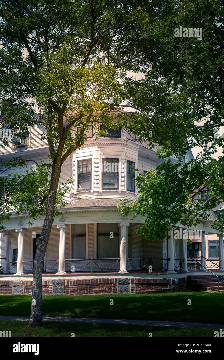 Una vecchia casa a tre piani in stile architettonico Queen Anne con veranda avvolgente e dettagli ringhiera a catena a St. Cloud, Minnesota, USA Foto Stock