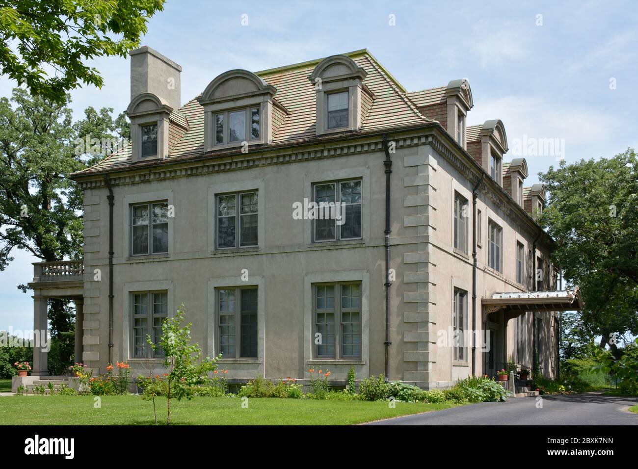 Una suggestiva villa francese in stile Beaux Arts, con un tetto mansarda con finestre ad arco in dormitori nella piccola città America, St. Cloud, MN, USA Foto Stock