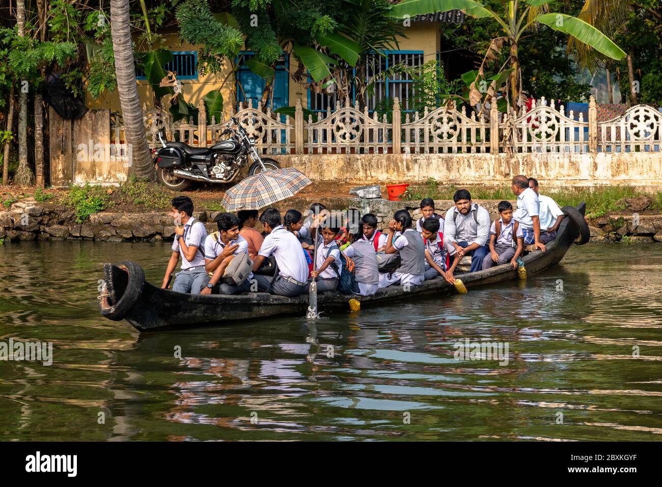 Studenti che vanno a scuola in acque retrovie del Kerala, India Foto Stock