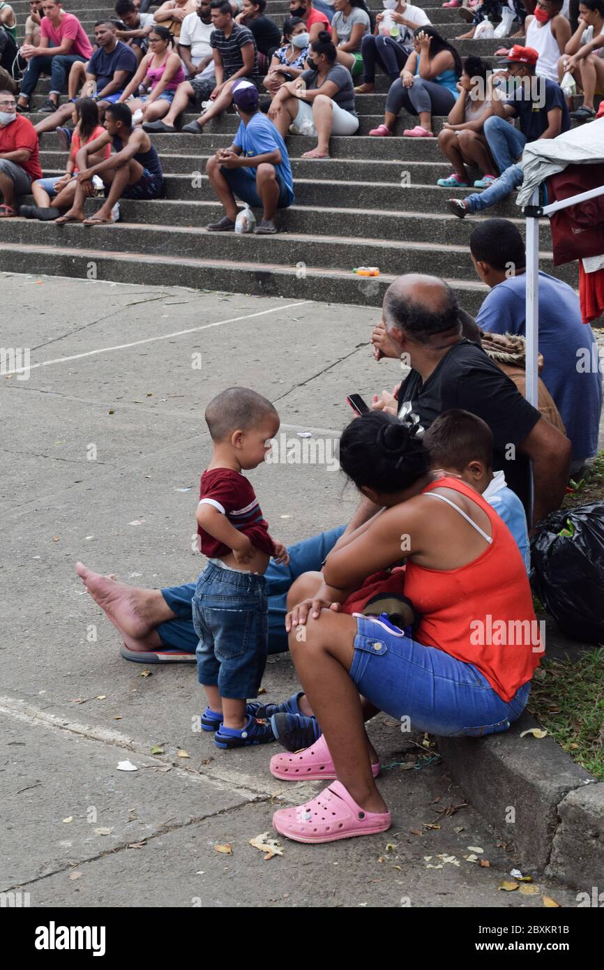 I venezuelani bloccati in campo improvvisato ricevono aiuti alimentari dalla fondazione 'Jesús Pescador de Hombres', a Cali, che prepara centinaia e distribuisce Foto Stock