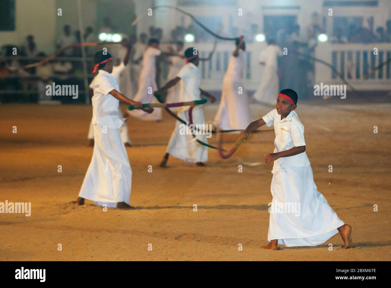 I frusta entrano nel campo della processione al Kataragama Festival. Essi  raffigurano il suono del fulmine e del tuono all'inizio della processio  Foto stock - Alamy