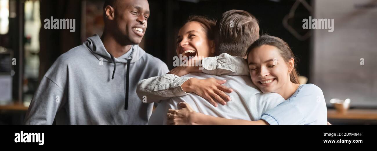 Amici multietnici incontrare il compagno coccolarlo si sente felice Foto Stock