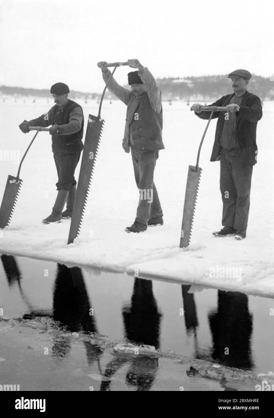 Lavoratori che raccolgono ghiaccio. Due uomini sono blocchi di segatura di ghiaccio da usare in case per mantenere alimentari fresco. Svezia 1922 Foto Stock